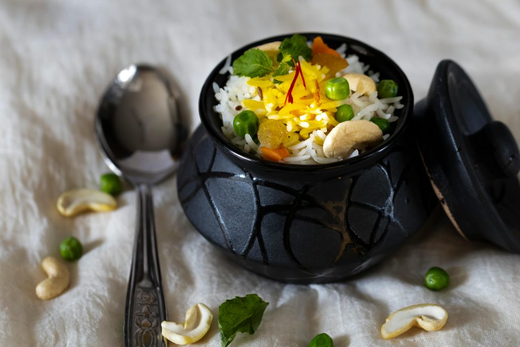 Authentic Indian rice with peas, cashews, and saffron in a black pot. Perfect for culinary themes.