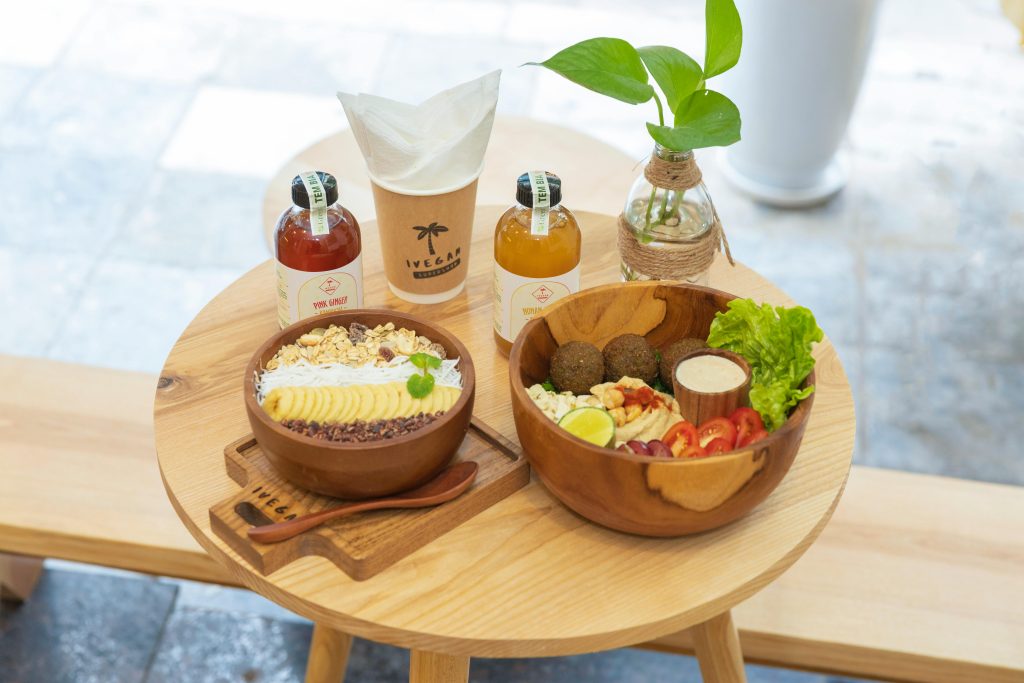 Delicious vegan breakfast bowl with fresh fruits, grains, and juice served on a wooden table.